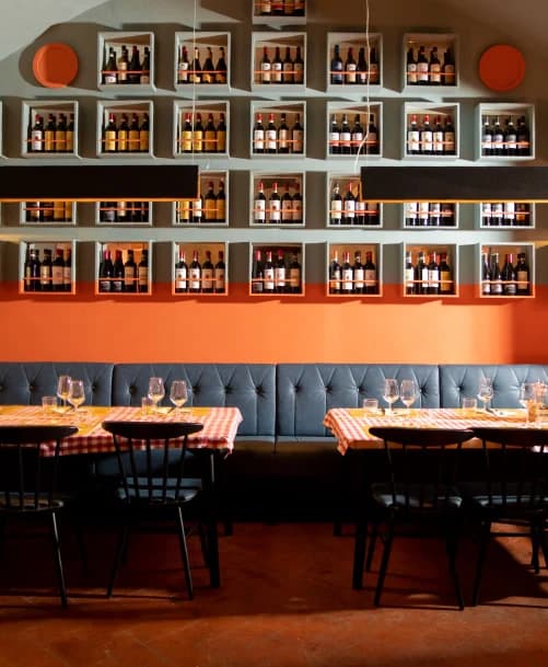 La sala dell’osteria, tra vini toscani e tavole apparecchiate